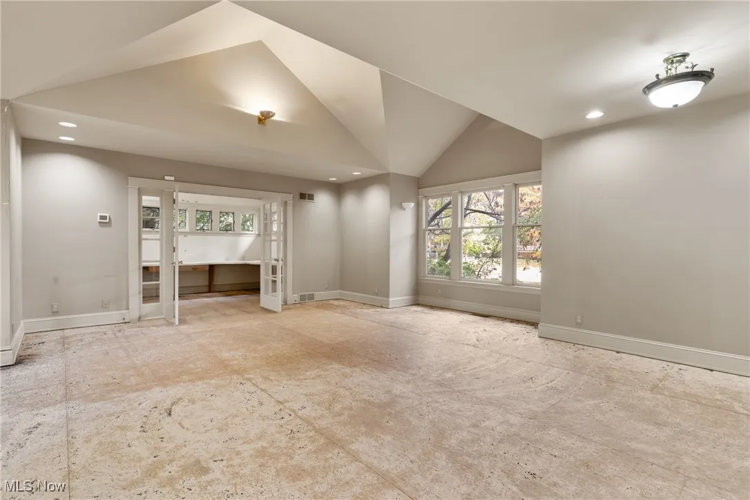 Empty room featuring recessed lighting and high vaulted ceiling