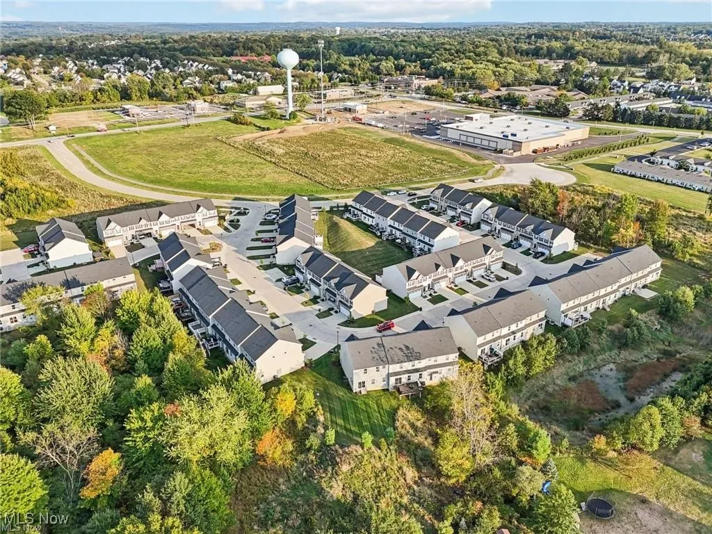 Aerial view of property and surrounding area with a tree filled landscape
