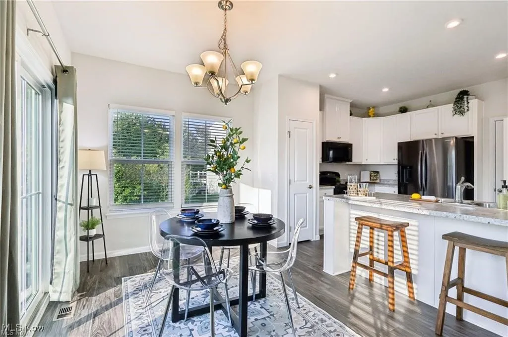 Dining space featuring dark wood-style floors, recessed lighting, and a chandelier