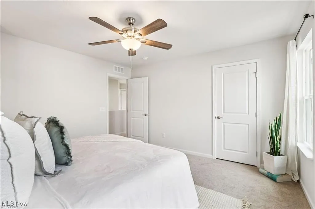 Carpeted bedroom featuring baseboards and ceiling fan