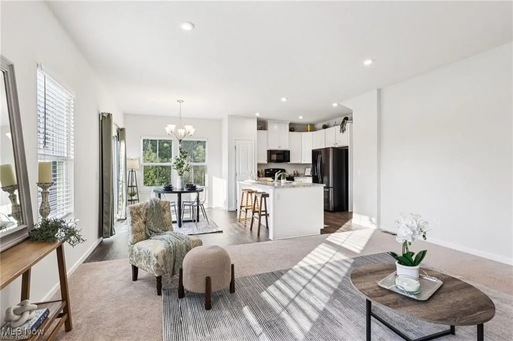 Living room with recessed lighting, light carpet, and a chandelier