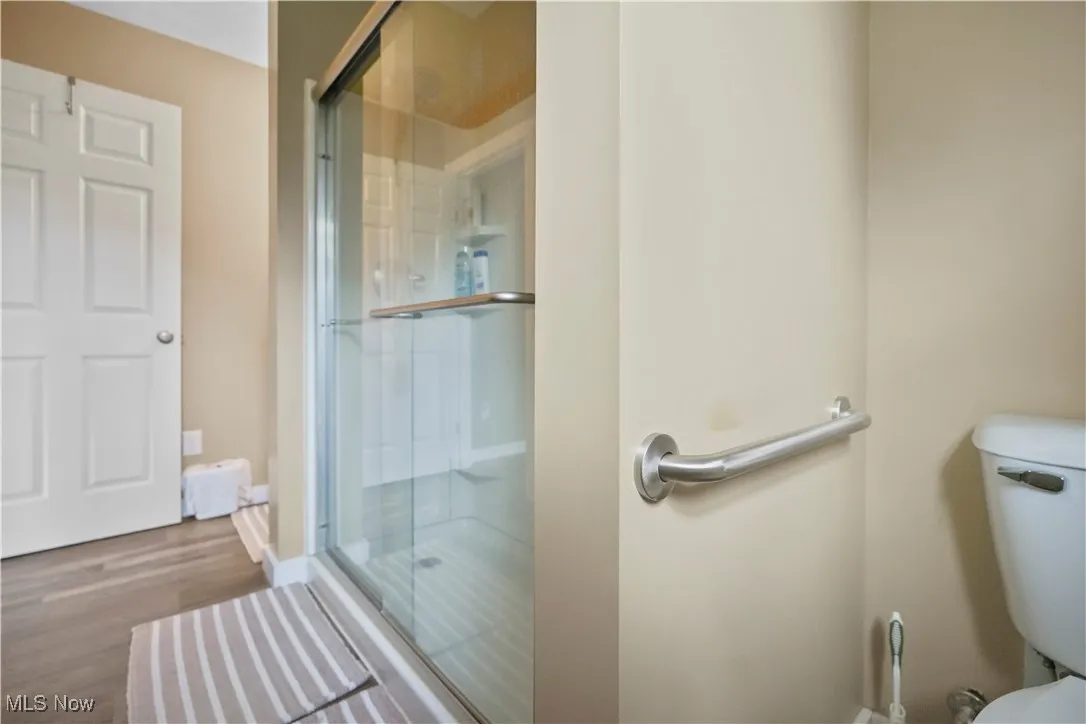 Full bathroom featuring a stall shower and wood finished floors
