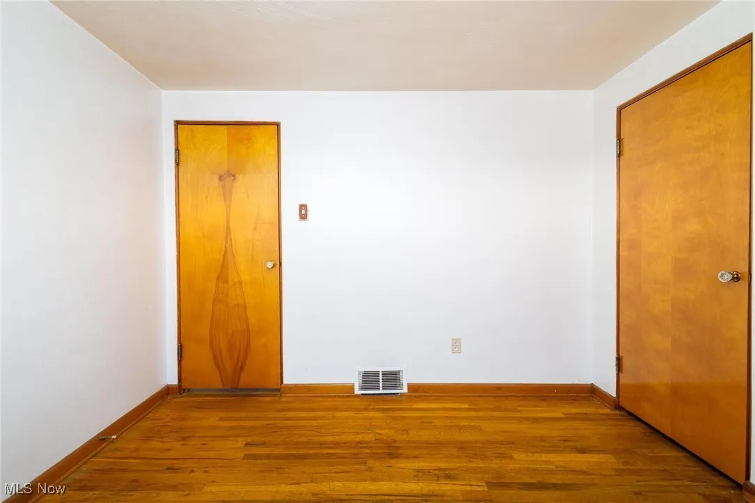 Empty room featuring wood finished floors and baseboards