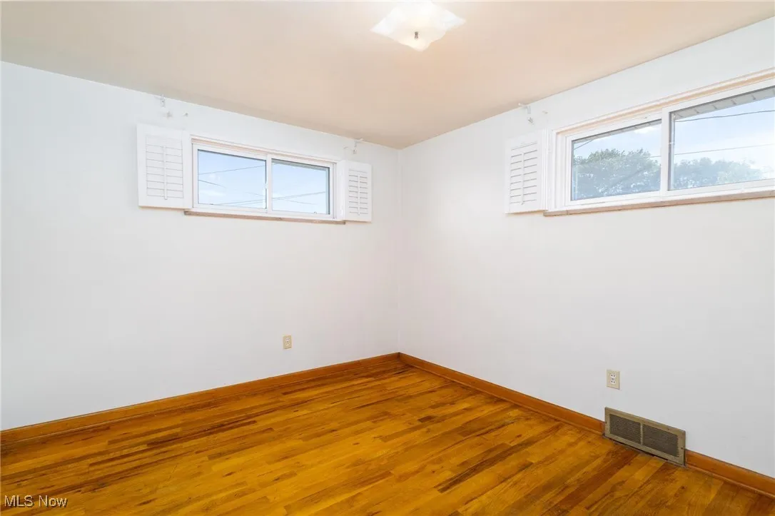 Unfurnished room featuring wood finished floors and baseboards