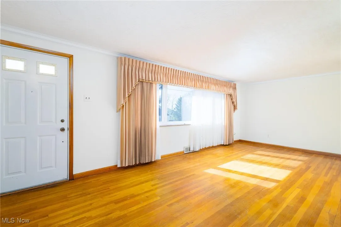 Entryway featuring crown molding and light wood-style floors