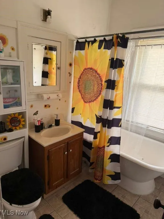 Full bathroom with a freestanding bath, vanity, and a shower with shower curtain