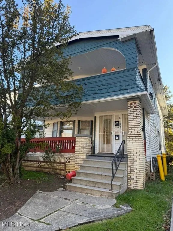 View of front of property with covered porch and brick siding