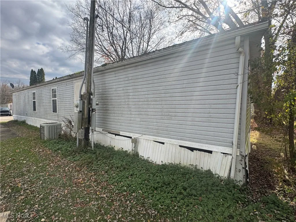View of side of property with a cooling unit
