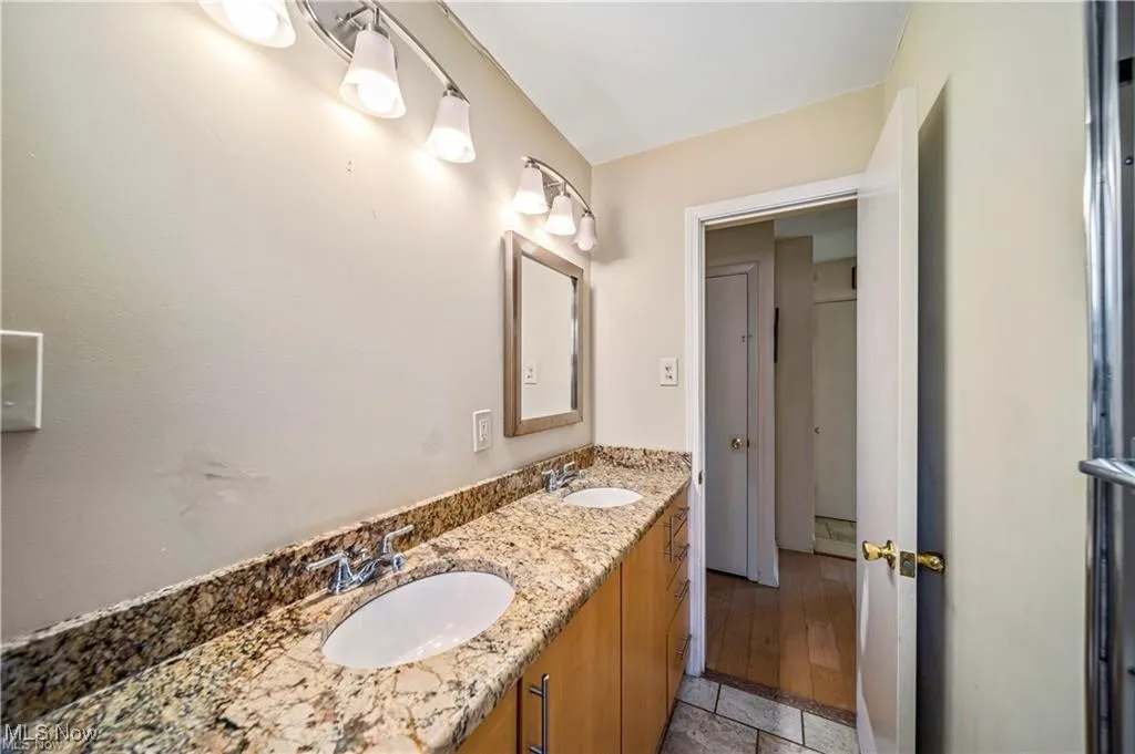Full bathroom featuring double vanity and light tile patterned floors