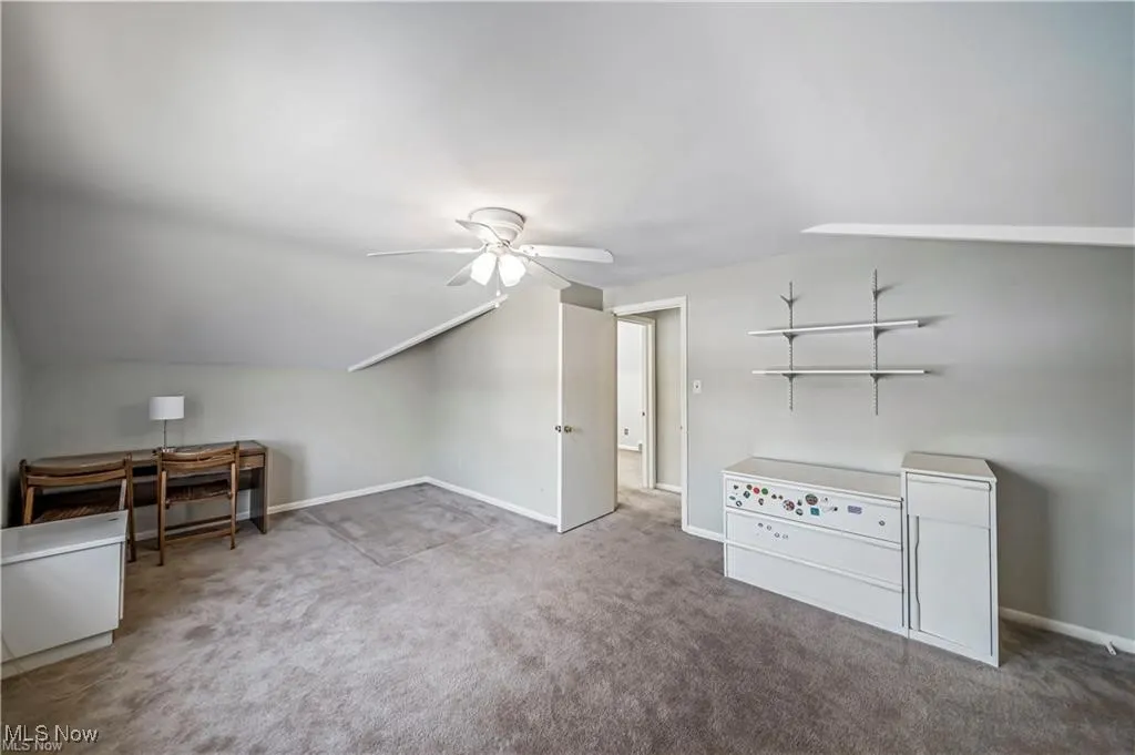 Bonus room with carpet flooring, lofted ceiling, and a ceiling fan