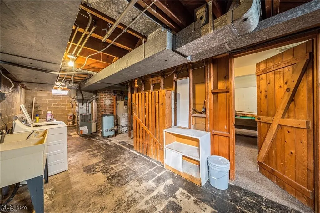Unfinished basement featuring water heater and heating unit