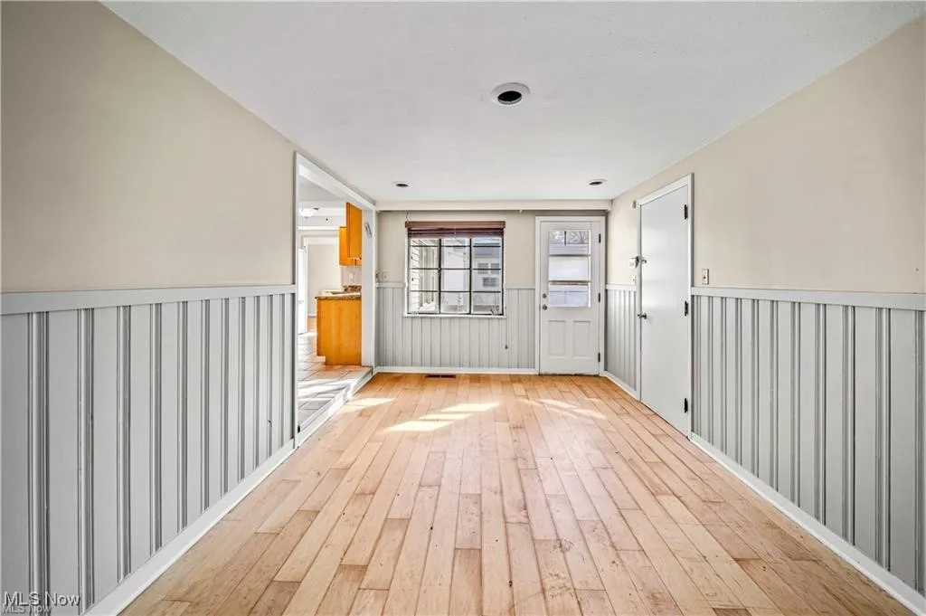 Unfurnished room featuring wainscoting and wood-type flooring