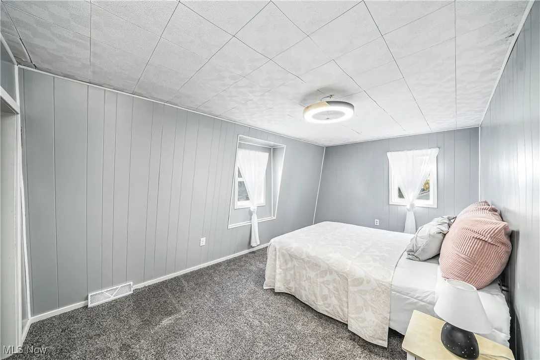 Bedroom with carpet floors and wooden walls