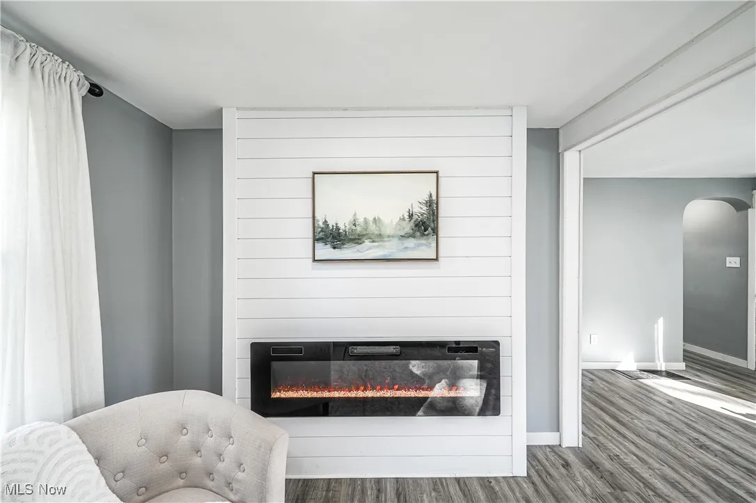 Detailed view of arched walkways, wood finished floors, and a fireplace