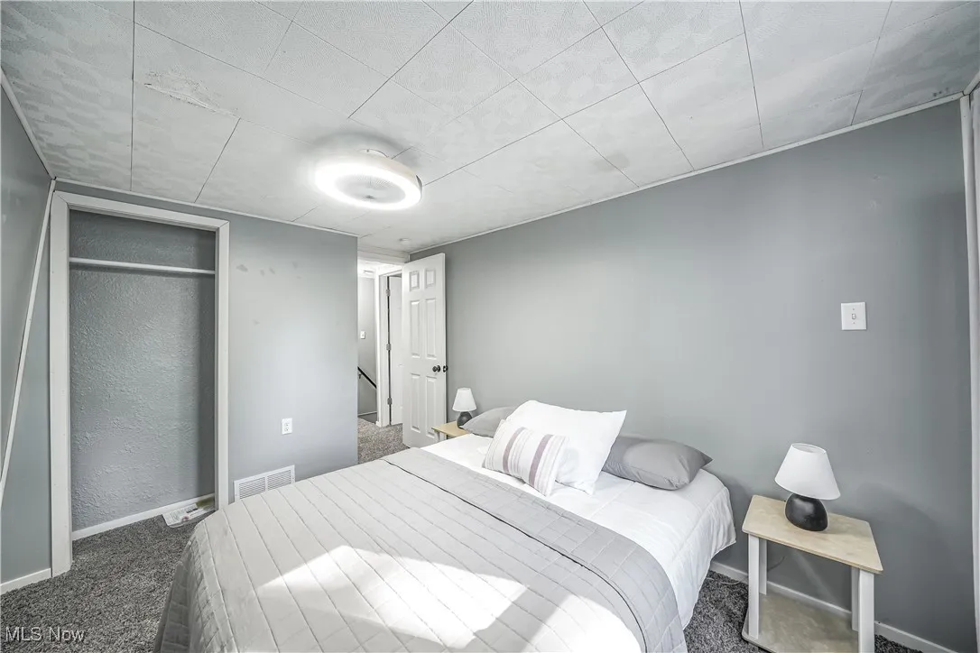 Bedroom with dark carpet and a closet