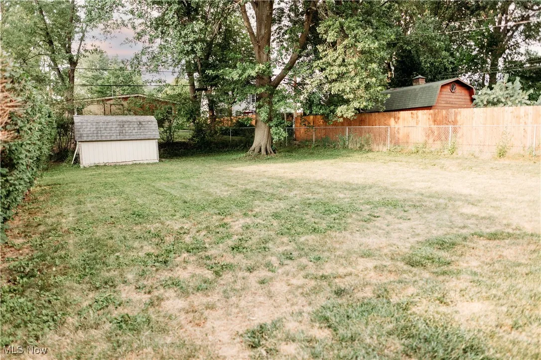 Fenced backyard featuring a storage shed