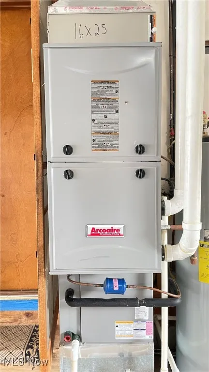 Utility room featuring water heater and heating unit