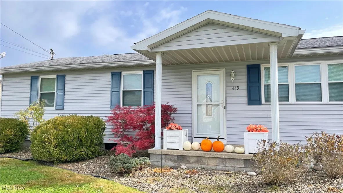 View of exterior entry with covered porch and roof with shingles