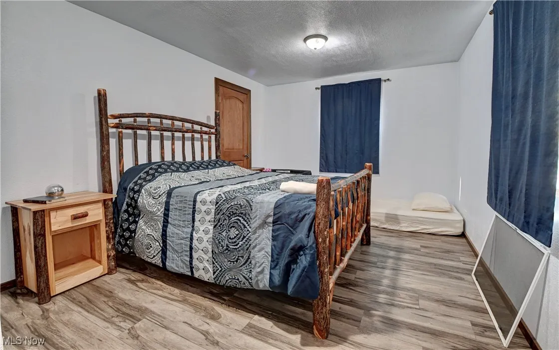 Bedroom featuring a textured ceiling and wood finished floors