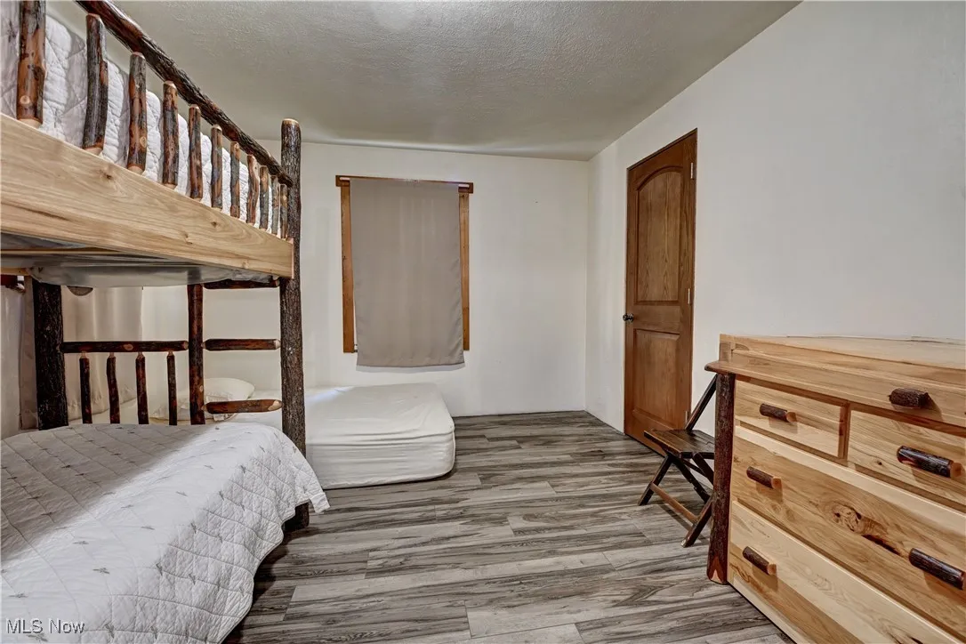 Bedroom with light wood-type flooring and a textured ceiling