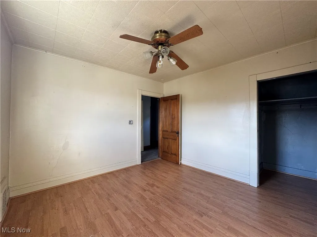 Unfurnished bedroom with wood finished floors, a closet, and ceiling fan