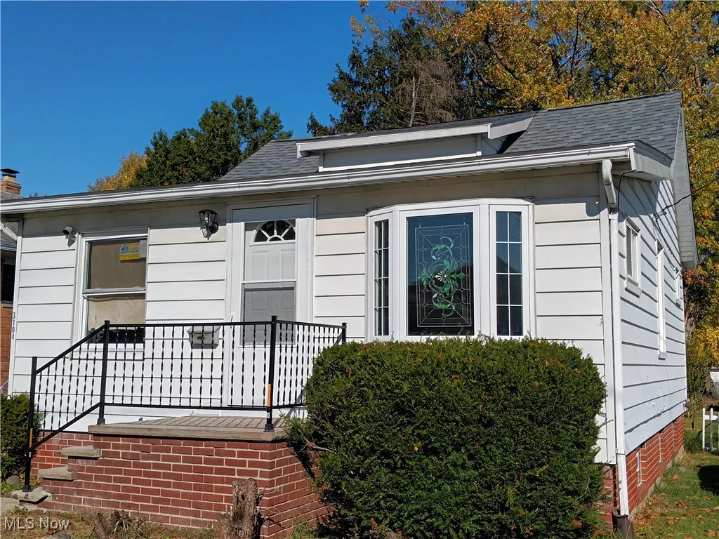 View of front of house featuring a deck, a shingled roof, and crawl space