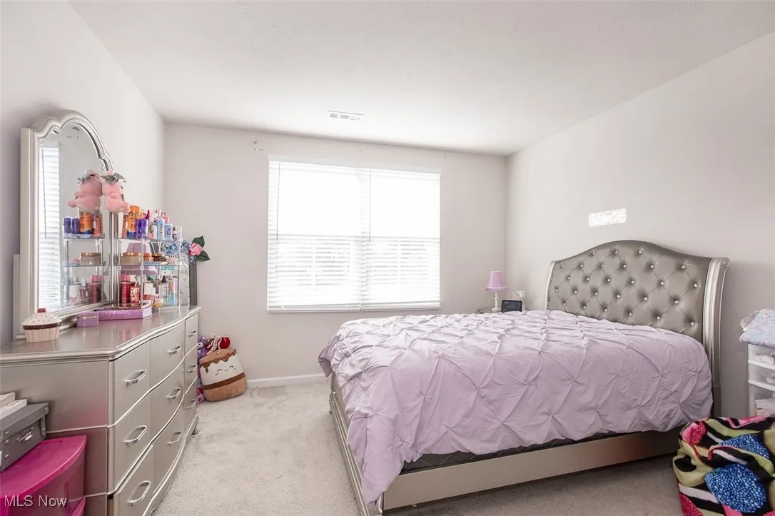Bedroom featuring light colored carpet and baseboards
