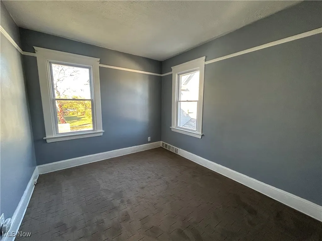 Empty room featuring baseboards and a textured ceiling
