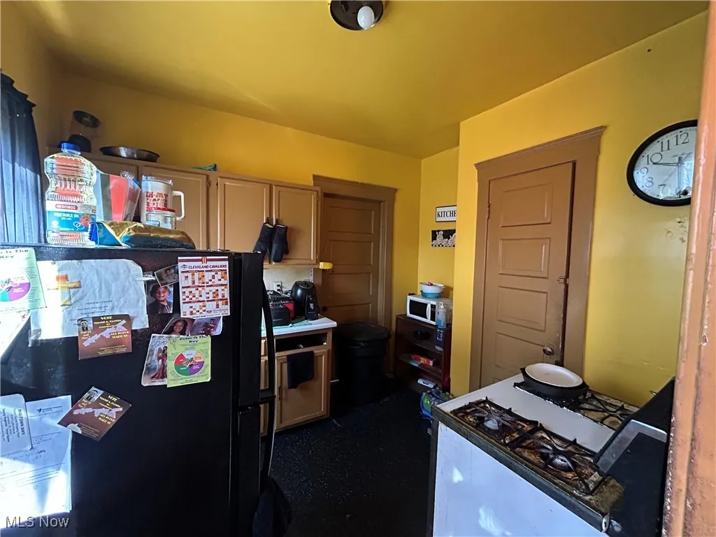Kitchen featuring freestanding refrigerator and white range with gas cooktop