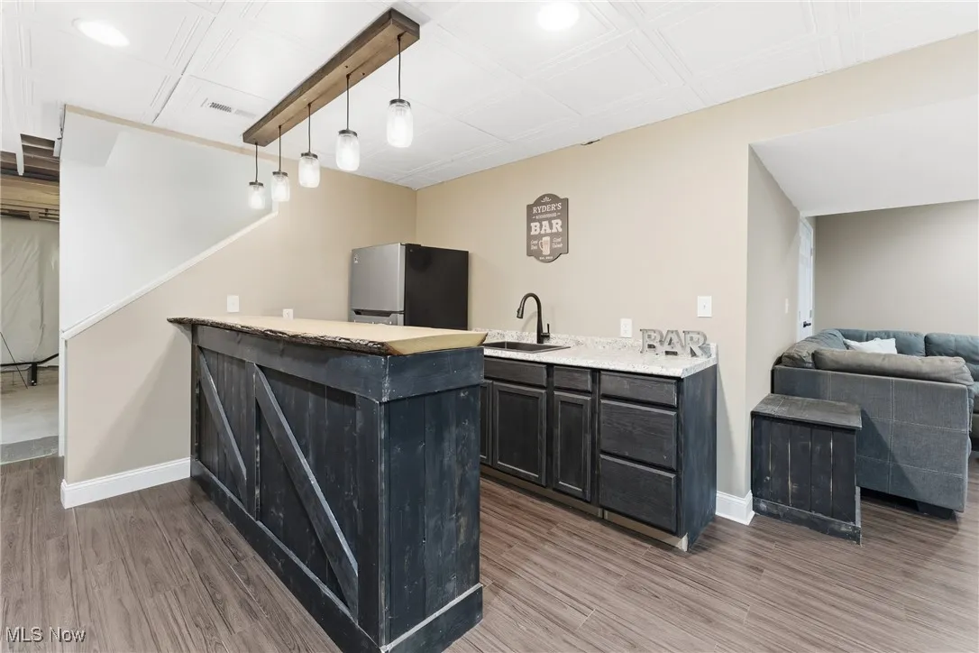 Bar area featuring decorative light fixtures, freestanding refrigerator, dark wood finished floors, an ornate ceiling, and recessed lighting