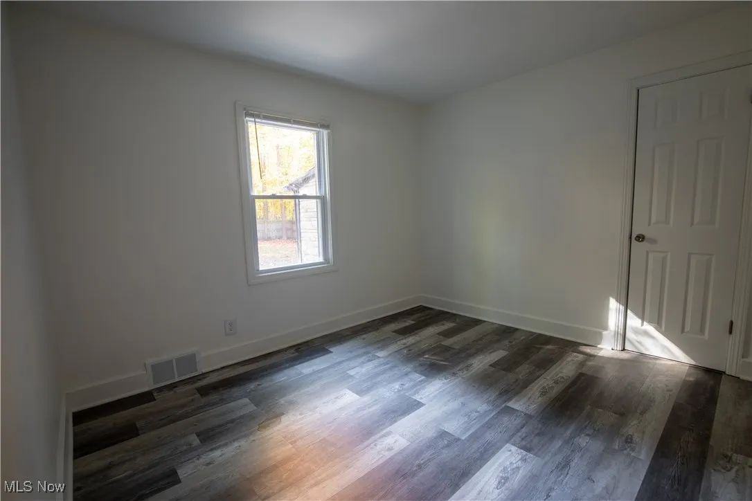 Empty room with dark wood-type flooring