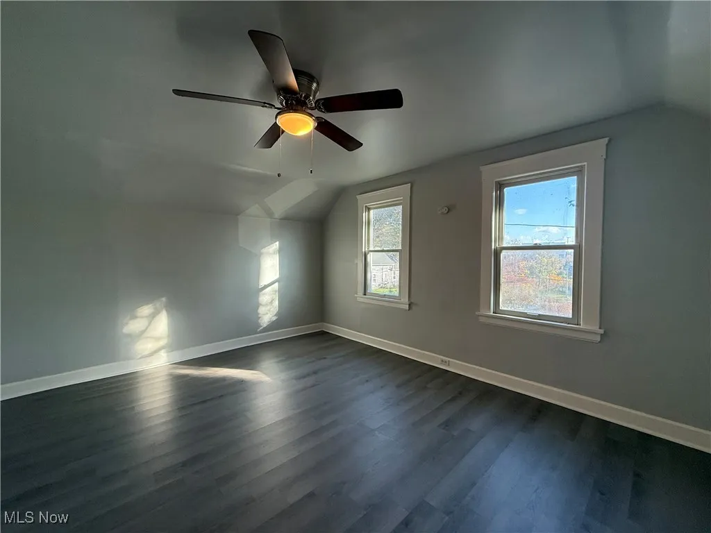 Bonus room featuring lofted ceiling, dark wood-style flooring, and a ceiling fan