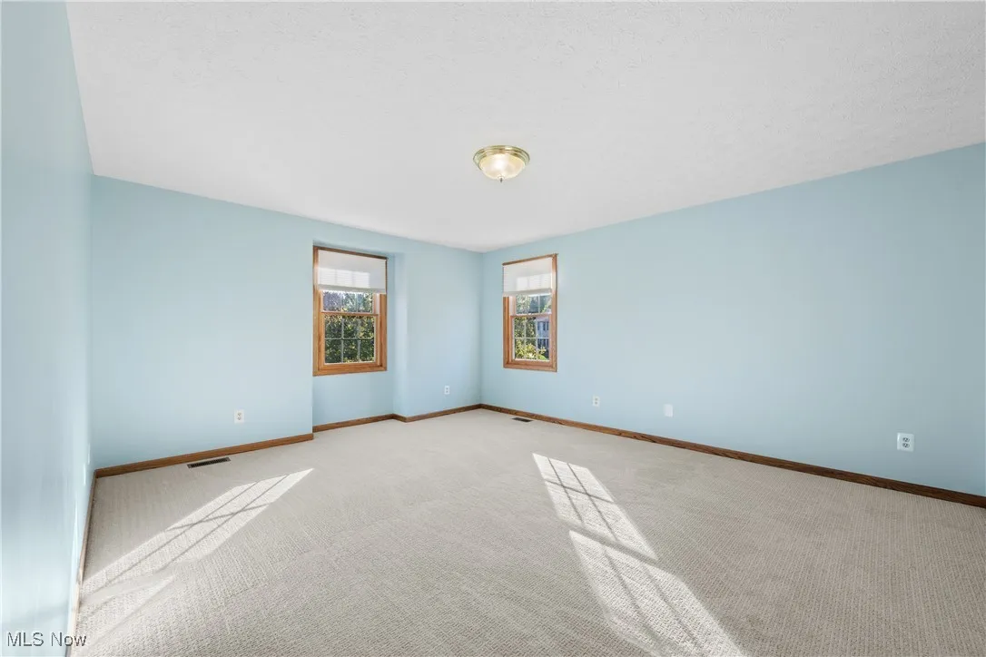 Brand new carpeting in this spacious and serene primary bedroom with walk-in closet.