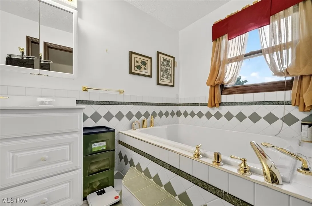 Full bath featuring a bath and vanity