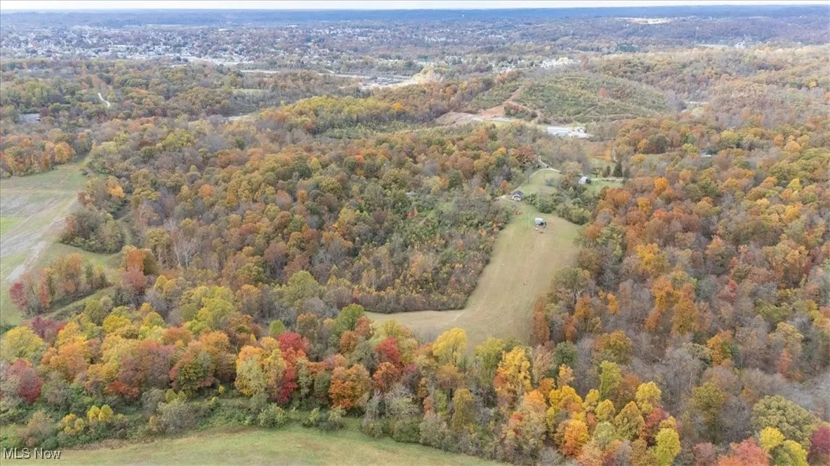 Aerial view of property's location with a heavily wooded area