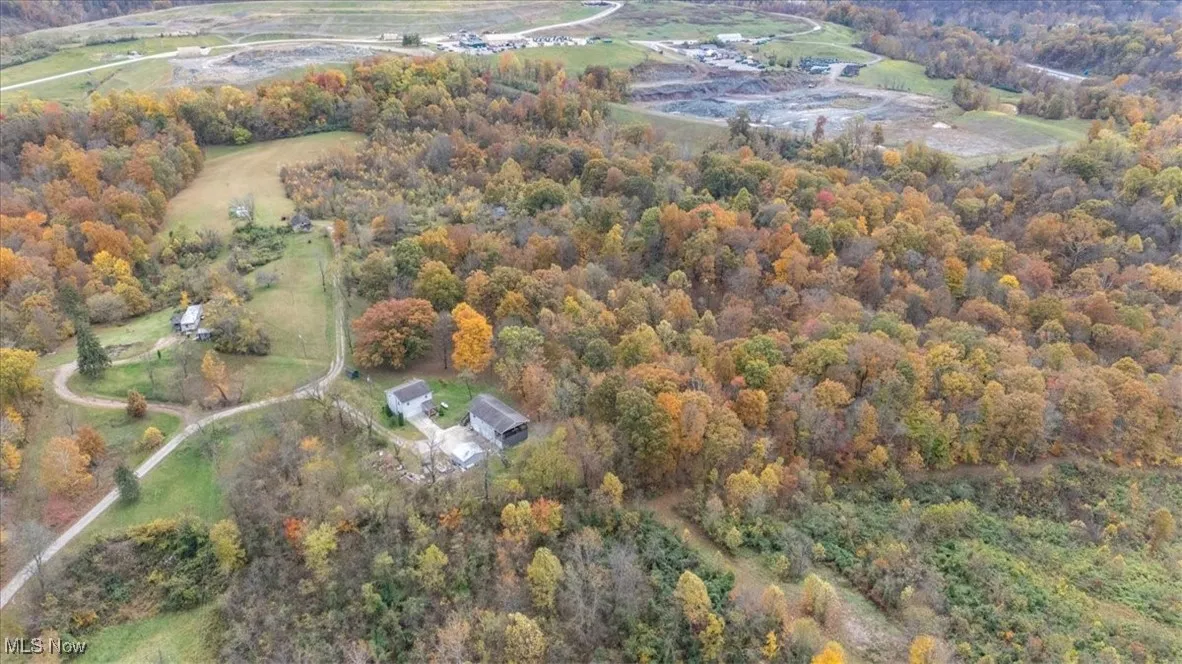 Aerial overview of property's location with a heavily wooded area