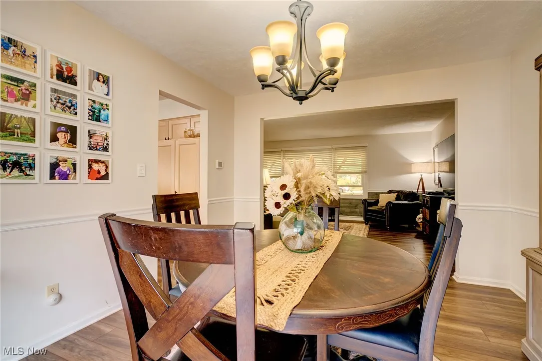 Dining room with wood finished floors and a chandelier