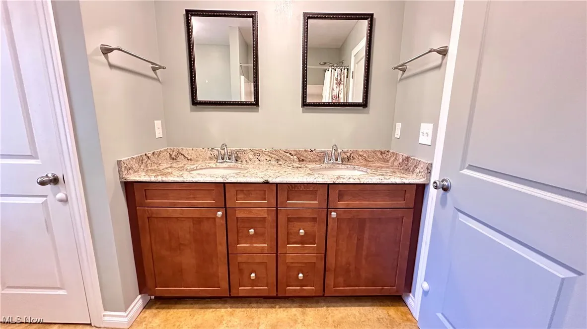 Full bath with double vanity and a shower with shower curtain