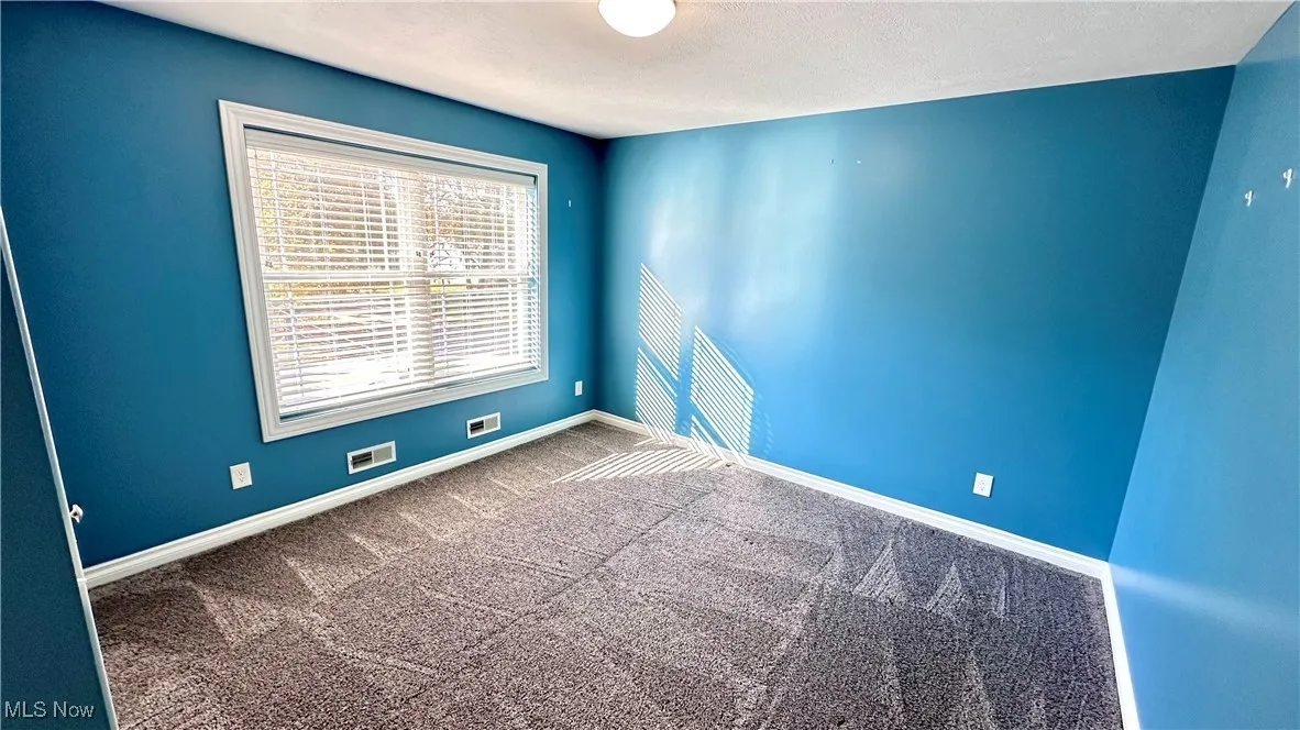 Spare room with carpet and a textured ceiling