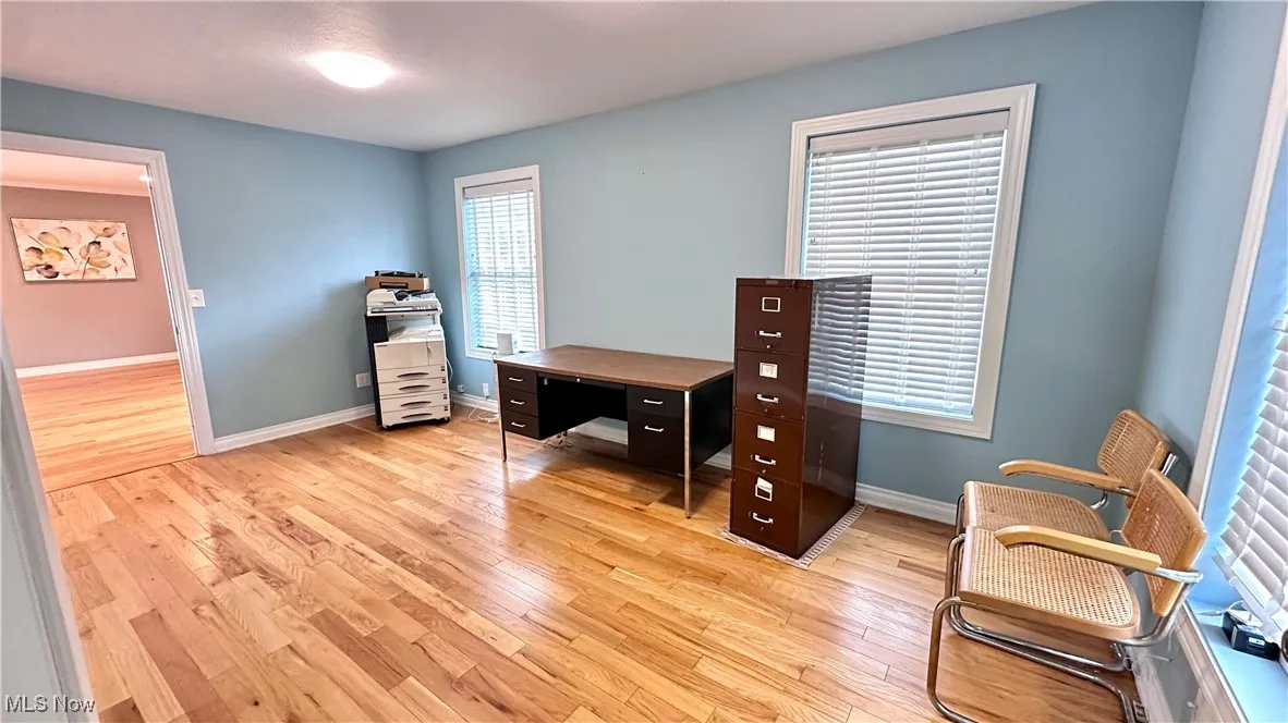 Office area featuring light wood-style flooring and baseboards