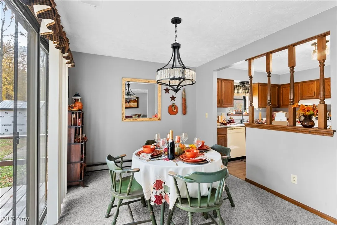 Dining area featuring light colored carpet and a chandelier