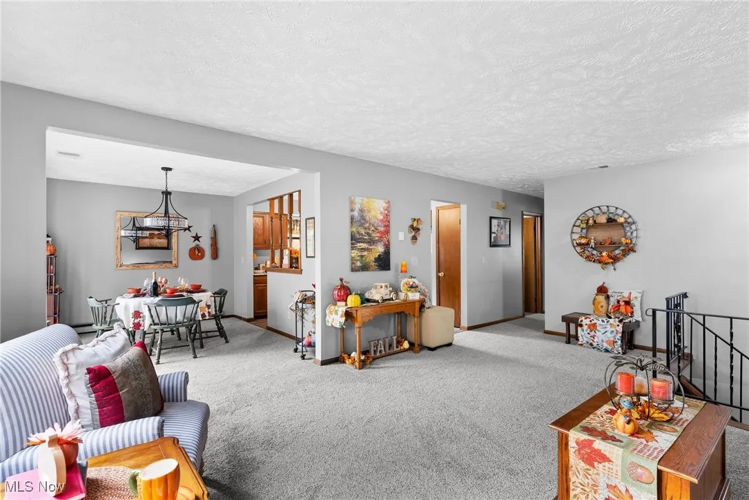 Carpeted living room with a textured ceiling and a chandelier