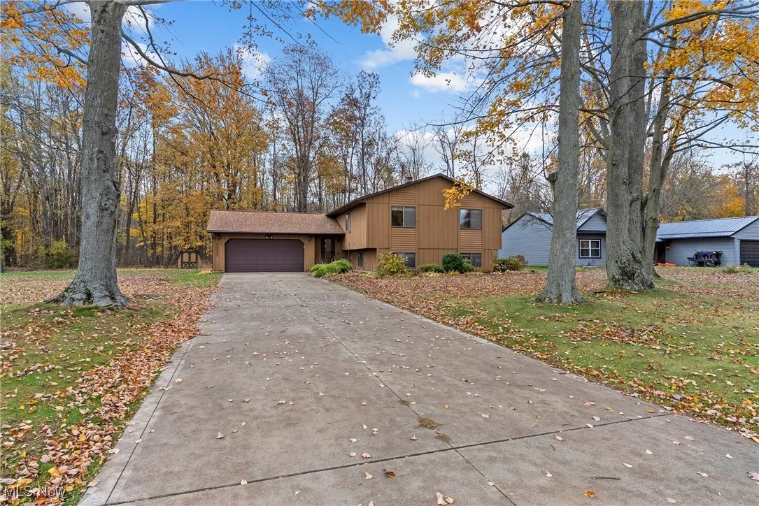 Tri-level home with a front yard, concrete driveway, and a garage