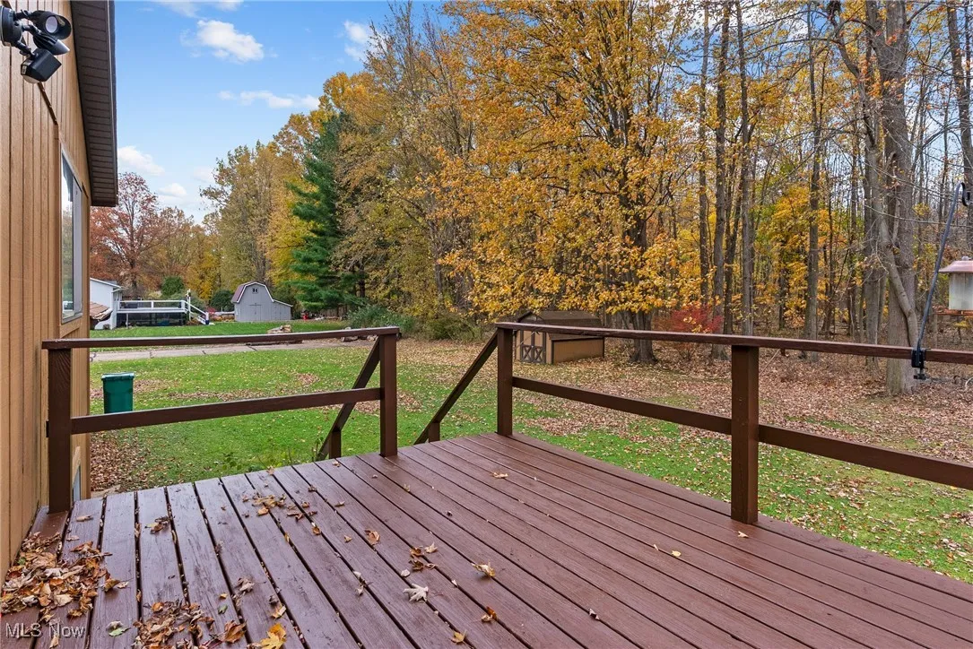 Wooden deck with a lawn and an outbuilding