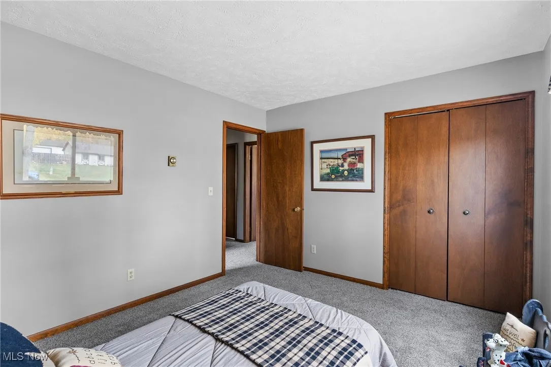 Bedroom with a closet, a textured ceiling, and carpet floors