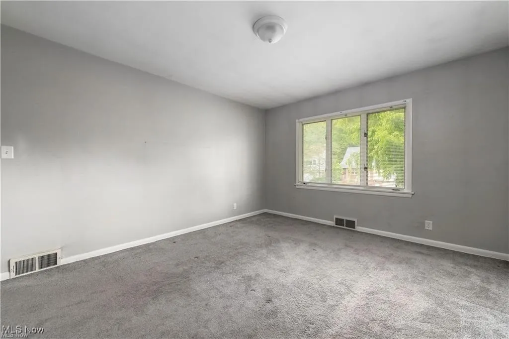 Carpeted empty room featuring baseboards