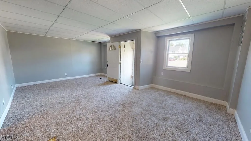Unfurnished room with light carpet and a drop ceiling
