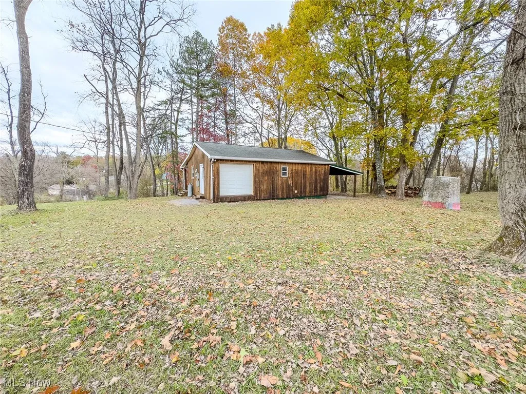 View of grassy yard featuring a garage