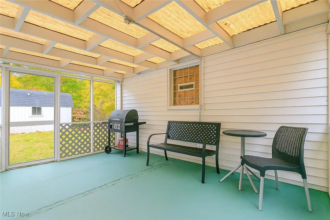 Sunroom / solarium featuring beam ceiling