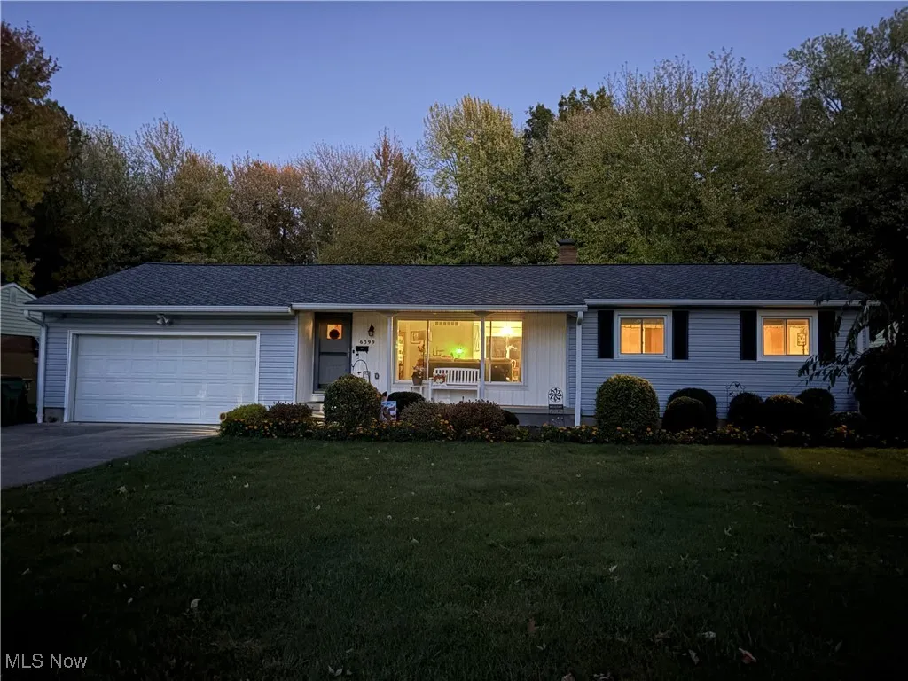Single story home with a porch, a front yard, concrete driveway, a garage, and a shingled roof